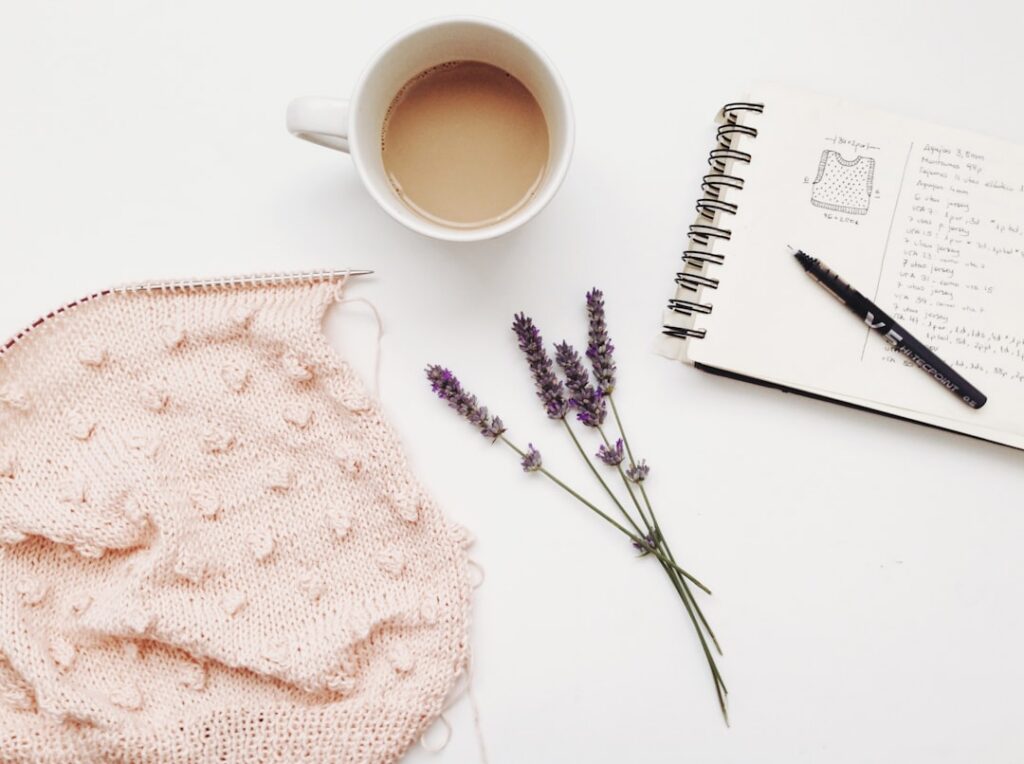 Notebook, lavender and knitting on a table; illustrative stock photograph.