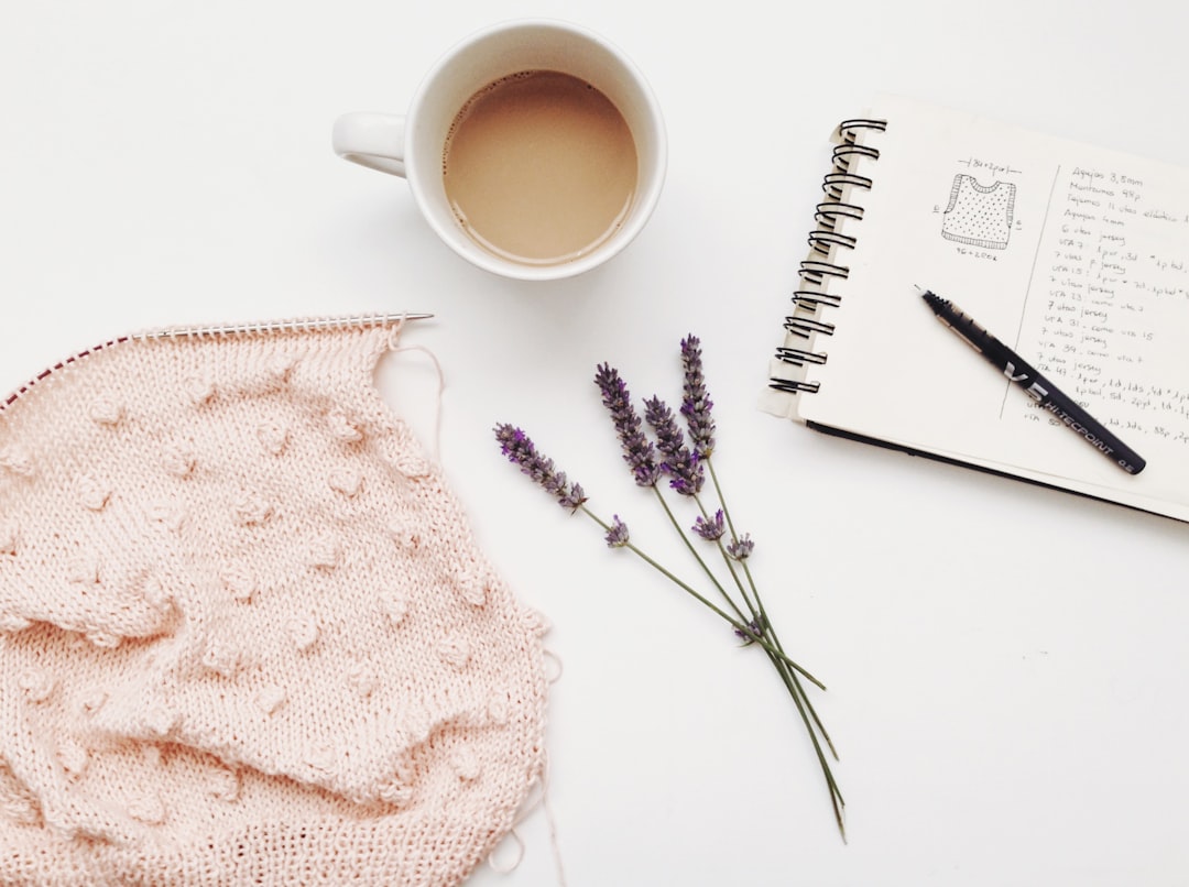 Notebook, lavender and knitting on a table; illustrative stock photograph.